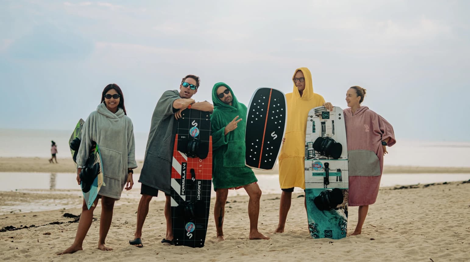 Un groupe de riders réuni sur une plage avec ses planches.